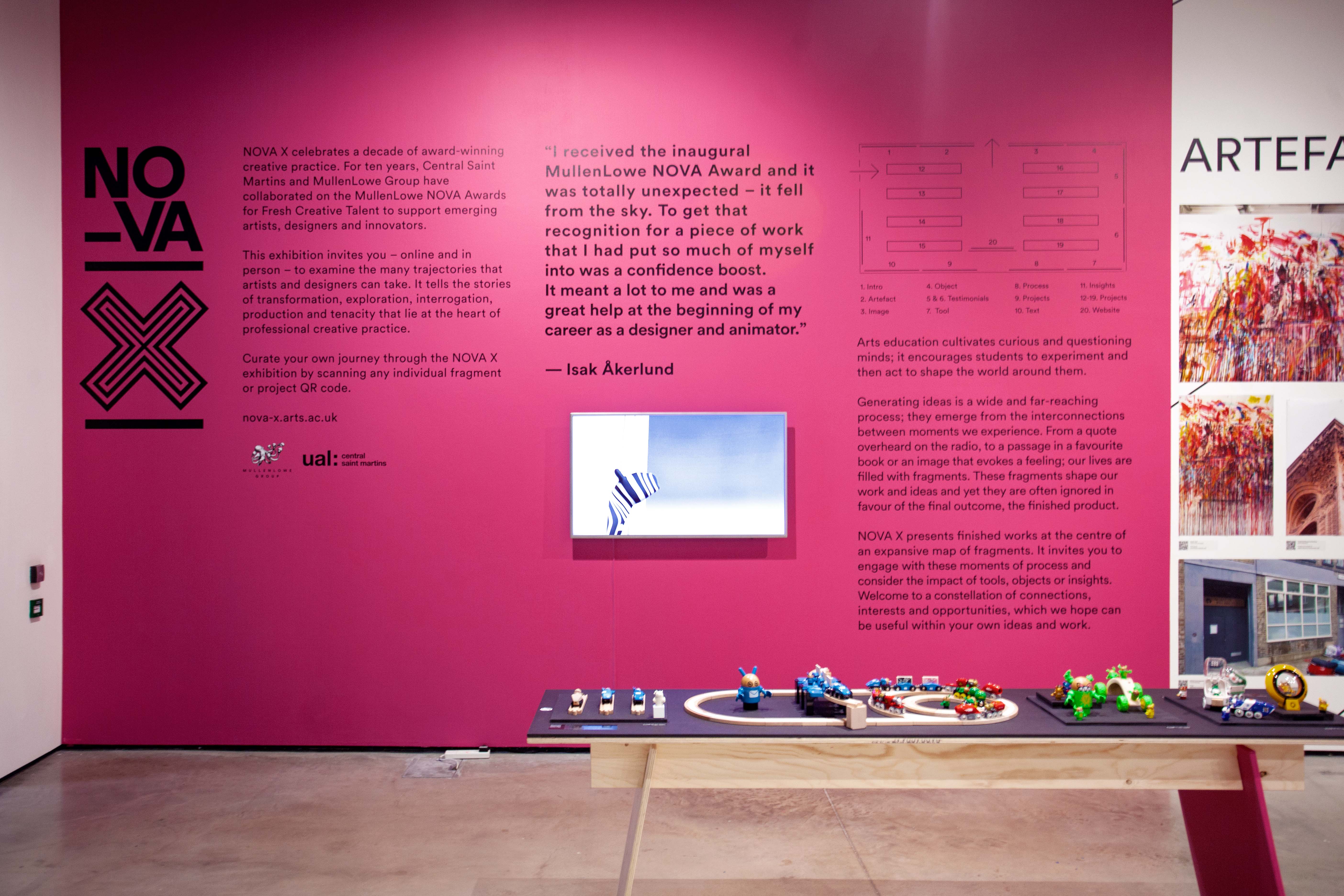 Nova X exhibition, a pink wall with exhibition text on it and a map of the gallery