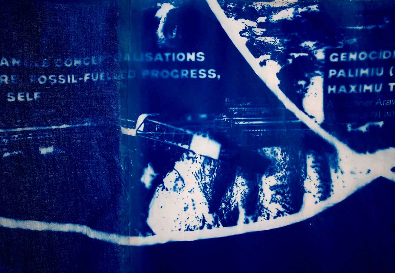 a close up of a large blue dyed material with a white pattern and faded text displayed on it