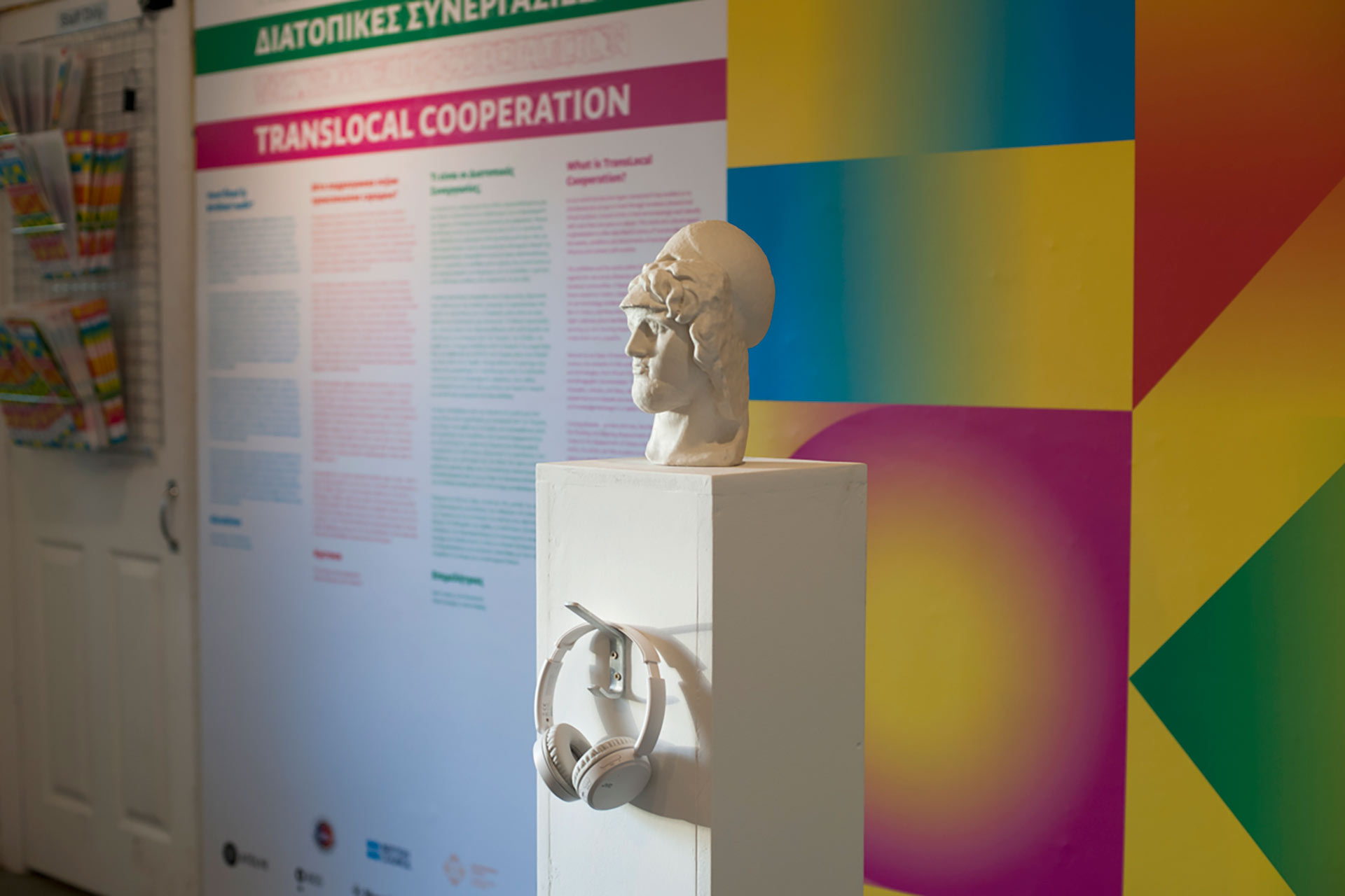 The image shows one of the artworks on display in front of the large wall print